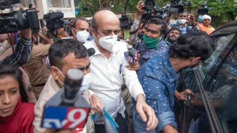 Getty Images MUMBAI, INDIA AUGUST 27: Bollywood actor Rhea Chakrabortys father Indrajit Chakraborty taken to ED office from Rhea's residence at Santacruz in connection with Sushant Singh Rajput's death case, on August 27, 2020 in Mumbai, India. The Enforcement Directorate (ED) probing the money laundering angle in Bollywood actor Sushant Singh Rajputs death questioned Rhea Chakrabortys father for the second time for nearly six hours on Thursday.