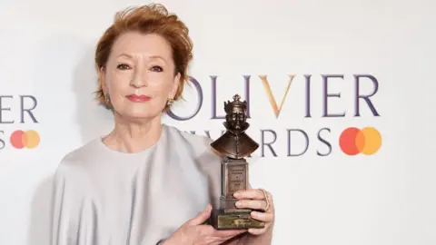 PA Media Lesley Manville holding her Olivier Award