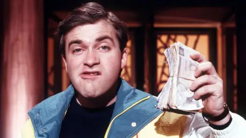 ITV/Shutterstock Harry Enfield as Loadsamoney on Channel 4's Friday Night Live in 1988