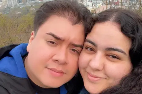 Contributor WWE devotee Jonny, with his fiancee Allison, smiling and both dark haired