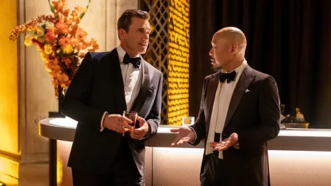 Apple TV+ A still of Jon Hamm and Hoon Lee chatting at a bar in Your Friends and Neighbors (Credit: Apple TV+)