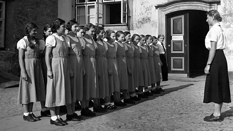 Alamy A black-and-white image of women standing in a line Handmaids style (Credit: Alamy)