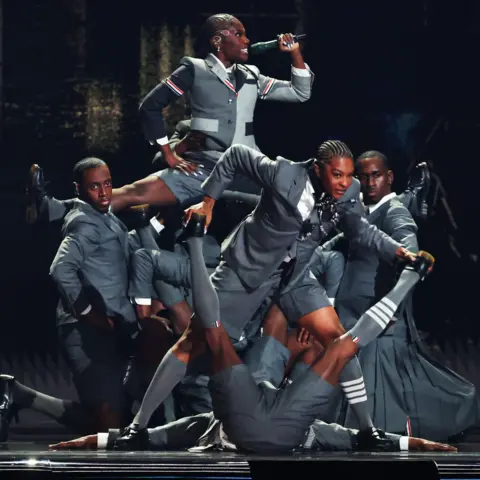 Getty Images Doechii performs the splits while being held aloft by dancers at the Grammy Awards