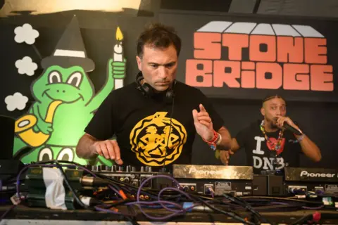 Getty Images Ros Atkins DJs at Glastonbury's Stone Bridge venue in 2024