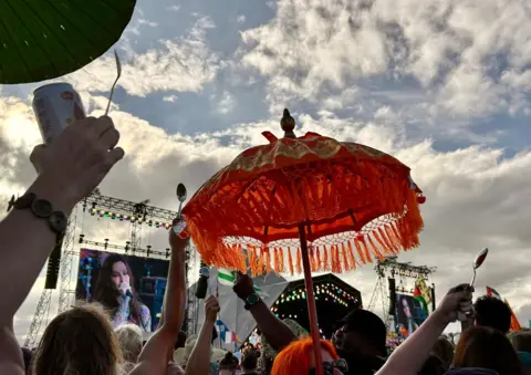 Fans hold aloft spoons during Alanis Morisette's set at Glastonbury