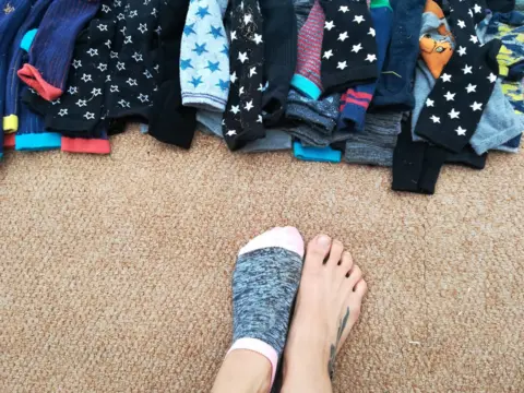 Sock Wrestling Federation Photo shows a pile of socks, and a child's feet, as they prepare for around of sock wrestling