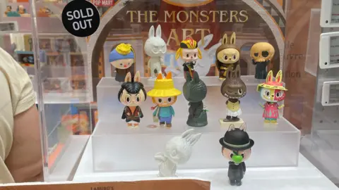 He Xiaoxiao/VCG via Getty Images Signs reading 'Sold Out' are seen on shelves displaying products of POP MART Labubu's Artistic Quest Limited Series