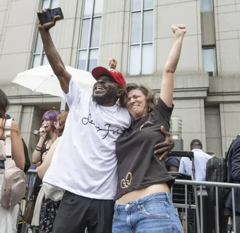 EPA Two supporters with their arms around each other and arms in the air