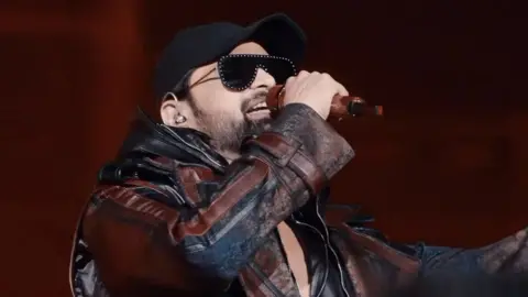 Himesh Reshammiya/Instagram Himesh Reshammiya seen singing at his concert in Delhi in a black jacket and cap 