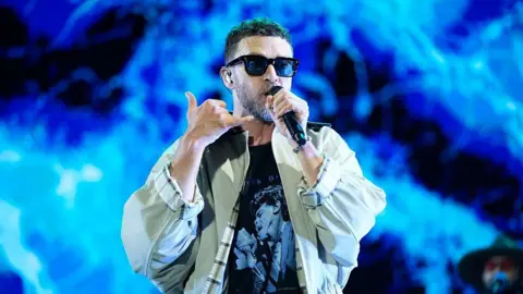 Getty Images Justin Timberlake holds the mic to his mouth on stage at the Iconica Santalucia Fest