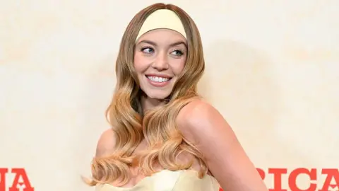 Getty Images Woman smiles in yellow headband and yellow dress