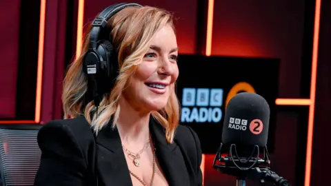 Sheridan Smith in the BBC Radio 2 studio, wearing headphones and speaking into the microphone