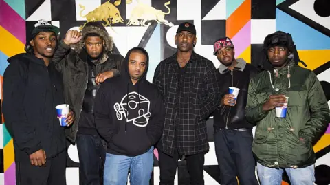 Tristan Fewings/Getty Images JME, Skepta and other members of Boy Better Know stood posing with hoodies and coats on