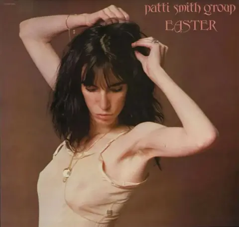 1977, Lynn Goldsmith/Arista Records Cover of Patti Smith's album Easter showing Patti in white strappy top.